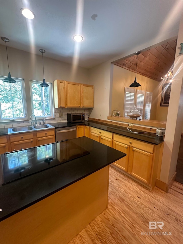 kitchen with stainless steel appliances, light hardwood / wood-style flooring, hanging light fixtures, and sink