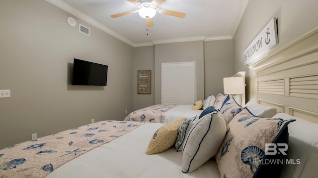 bedroom featuring ornamental molding, ceiling fan, and a closet