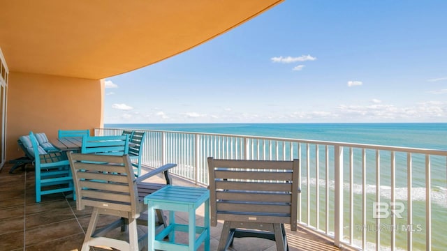 balcony featuring a view of the beach and a water view