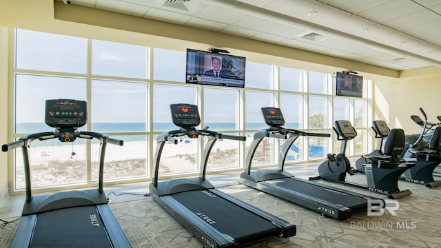 gym featuring a paneled ceiling and expansive windows