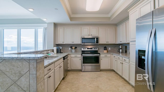 kitchen featuring sink, light stone countertops, kitchen peninsula, and appliances with stainless steel finishes