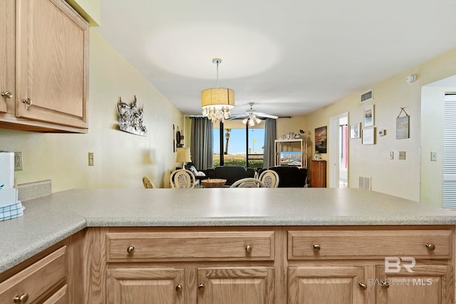 kitchen featuring decorative light fixtures, kitchen peninsula, light brown cabinets, and ceiling fan with notable chandelier