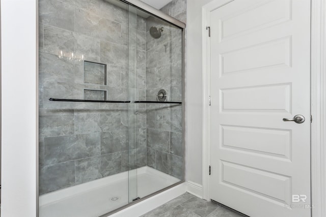 5885 Grotto Ave, Pensacola, FL 32507 - bathroom featuring a stall shower, marble look tiles, and baseboards