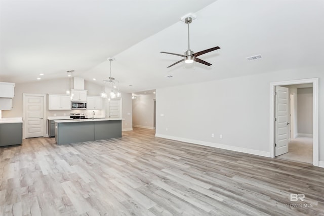 5885 Grotto Ave, Pensacola, FL 32507 - unfurnished living room with vaulted ceiling, ceiling fan, light wood-type flooring, baseboards, and a sink