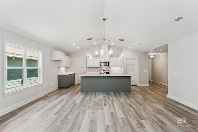 5885 Grotto Ave, Pensacola, FL 32507 - kitchen featuring stainless steel microwave, a sink, white cabinets, light wood finished floors, and light countertops
