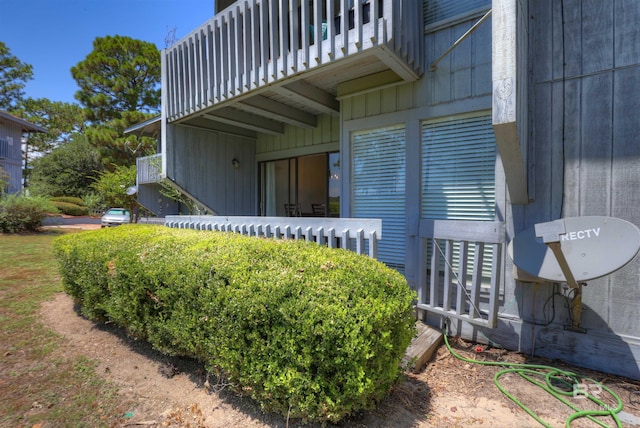 view of side of home with board and batten siding and a balcony