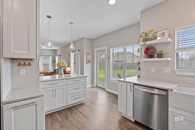 kitchen featuring open shelves, white cabinets, dishwasher, decorative light fixtures, and light wood-type flooring