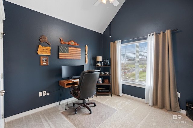 carpeted office space with ceiling fan, baseboards, and high vaulted ceiling