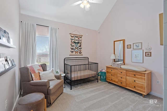 bedroom featuring a crib, baseboards, light carpet, high vaulted ceiling, and a ceiling fan