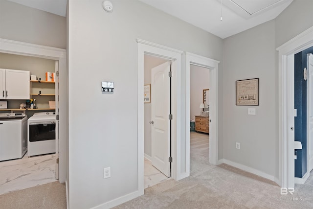 hallway with baseboards, attic access, marble finish floor, light colored carpet, and independent washer and dryer