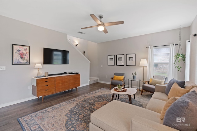 living area with dark wood finished floors, visible vents, baseboards, and a ceiling fan