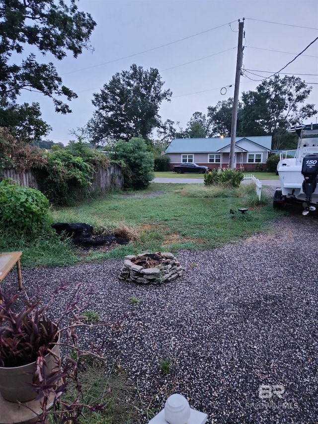 view of yard with fence and a fire pit