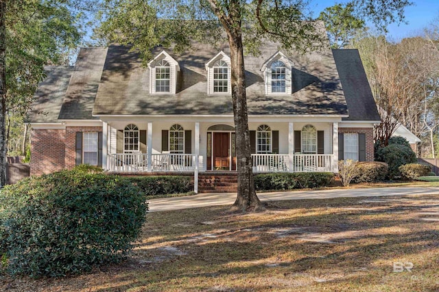 new england style home with a porch and brick siding