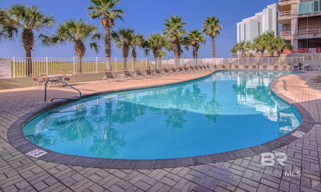 pool featuring fence and a patio