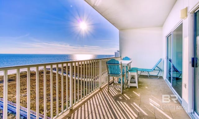 balcony with a water view and a view of the beach