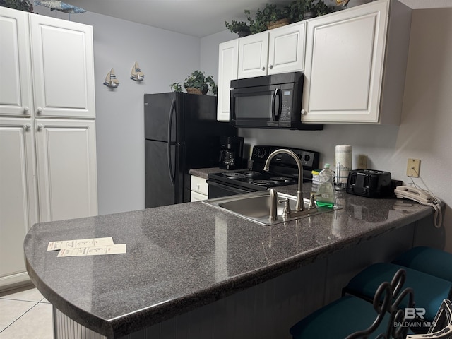 25805 Perdido Beach Blvd Unit 419, Orange Beach, AL 36561 - kitchen with a peninsula, dark countertops, white cabinets, a kitchen bar, and black appliances