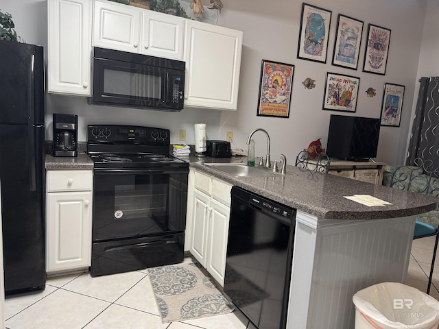 25805 Perdido Beach Blvd Unit 419, Orange Beach, AL 36561 - kitchen featuring a peninsula, black appliances, light tile patterned flooring, a sink, and dark countertops