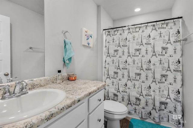 bathroom with a shower with shower curtain, vanity, and toilet