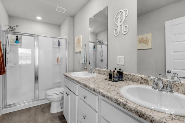 bathroom with toilet, vanity, wood-type flooring, and walk in shower