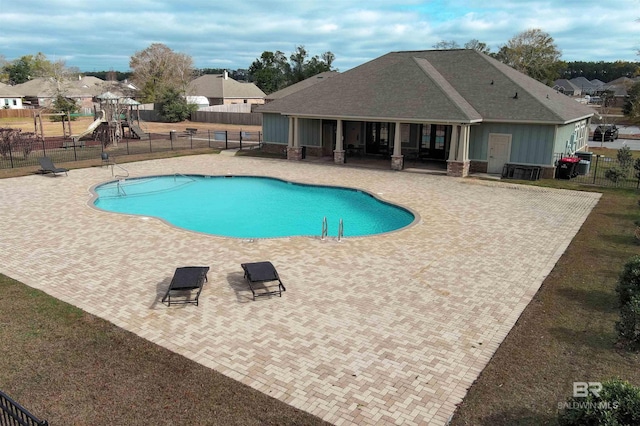 view of pool featuring a playground and a patio