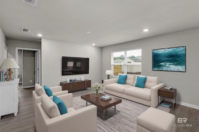 living room with hardwood / wood-style floors and a textured ceiling