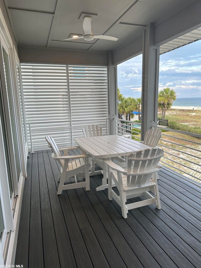 deck with ceiling fan and a water view