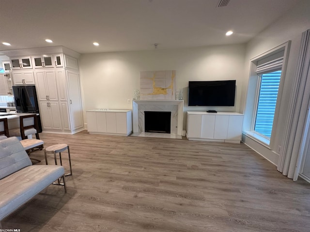 living room with a fireplace and light wood-type flooring