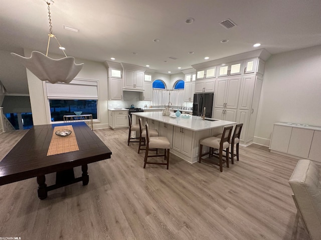 dining room featuring a notable chandelier, sink, and light hardwood / wood-style flooring