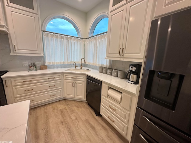 kitchen with white cabinetry, light hardwood / wood-style floors, sink, dishwasher, and stainless steel refrigerator with ice dispenser