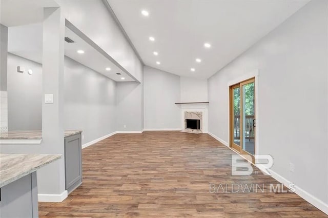 unfurnished living room featuring wood-type flooring and a high end fireplace