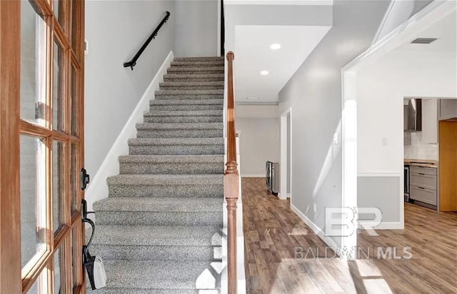 staircase with a wealth of natural light and wood-type flooring