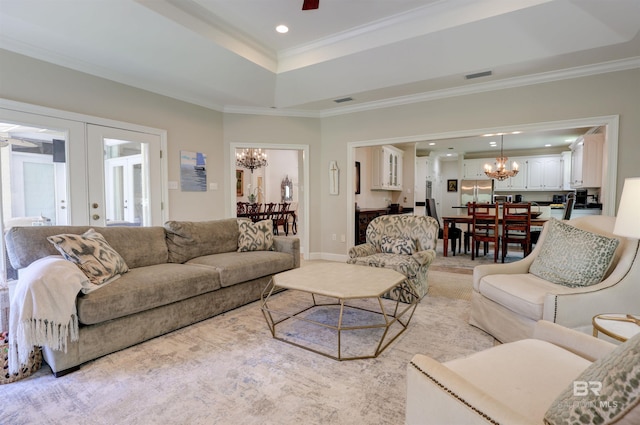 living room with ornamental molding, french doors, ceiling fan with notable chandelier, light carpet, and a tray ceiling