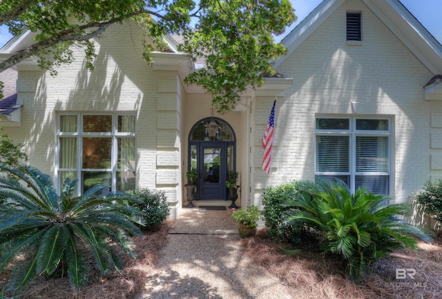 view of exterior entry with brick siding