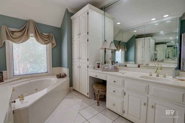 bathroom with a wealth of natural light, a tub to relax in, vanity, and tile patterned floors