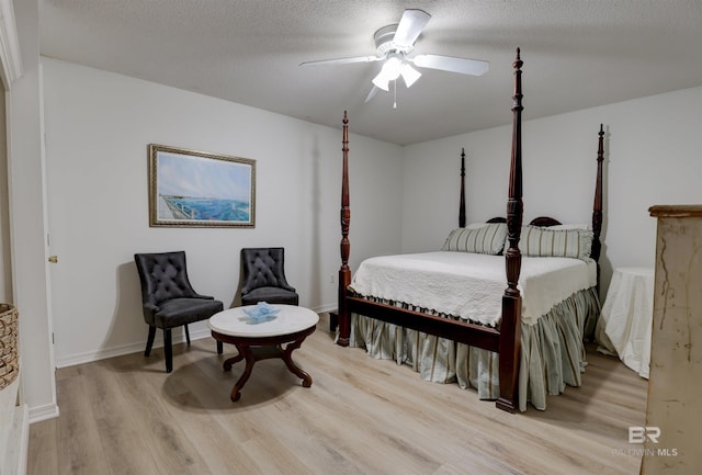 bedroom featuring ceiling fan, light hardwood / wood-style flooring, and a textured ceiling