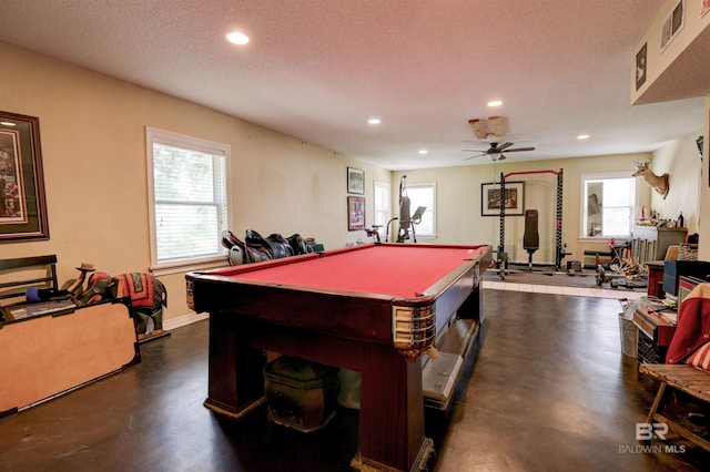 playroom featuring a textured ceiling, ceiling fan, pool table, and concrete flooring