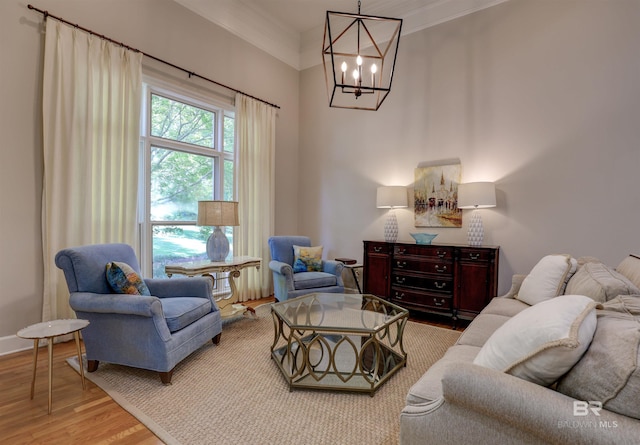 living room with a notable chandelier, light hardwood / wood-style floors, and ornamental molding