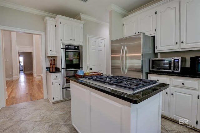 kitchen featuring white cabinets, a kitchen island, ornamental molding, and stainless steel appliances