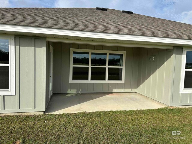 property entrance with a patio area and a lawn