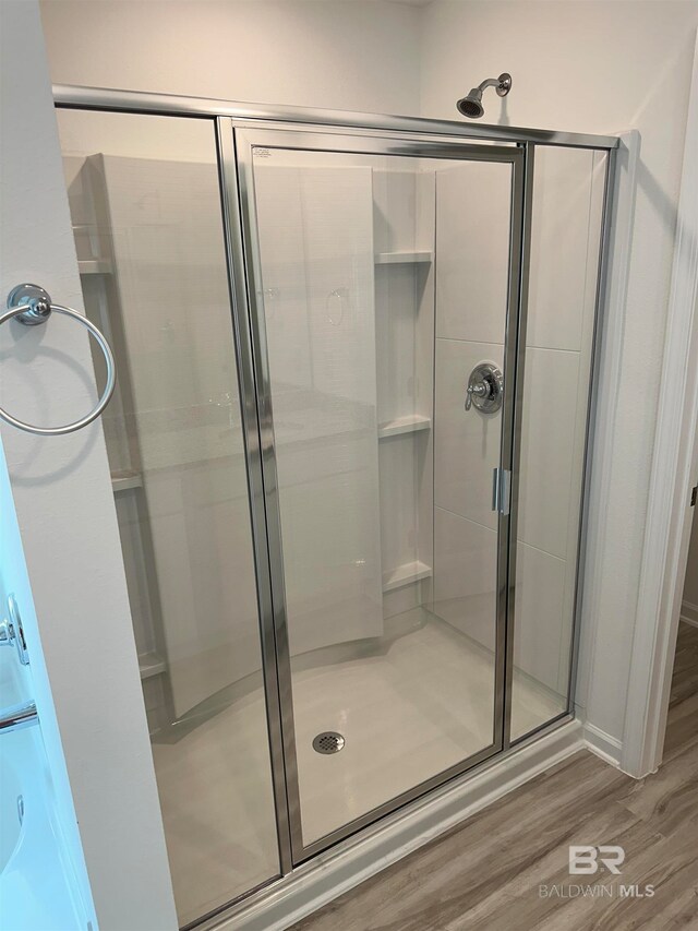 bathroom featuring hardwood / wood-style flooring and a shower with door