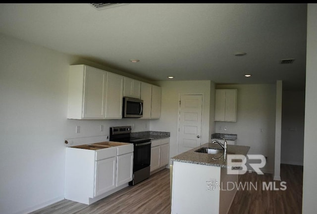 kitchen featuring white cabinetry, appliances with stainless steel finishes, light wood-type flooring, and an island with sink