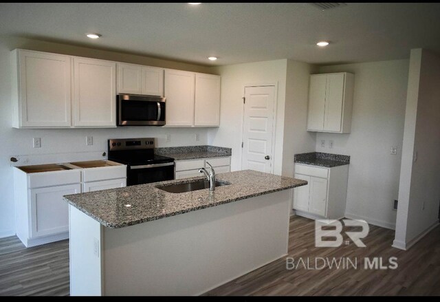 kitchen featuring a kitchen island with sink, black electric range, white cabinets, and sink