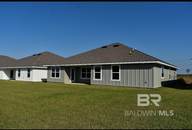 rear view of house featuring a yard