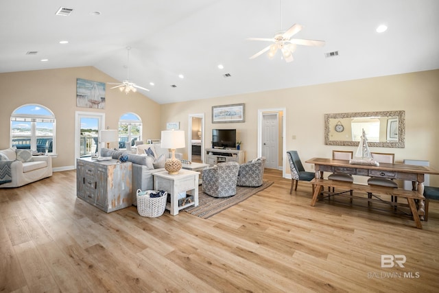 living area with visible vents, high vaulted ceiling, light wood-style flooring, and a ceiling fan