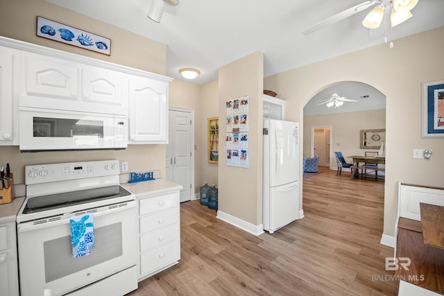 kitchen with white cabinetry, white appliances, arched walkways, light wood finished floors, and light countertops