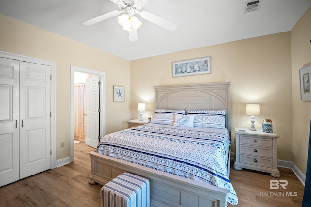 bedroom with a closet, visible vents, baseboards, and wood finished floors