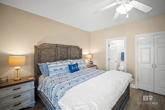 bedroom featuring a ceiling fan, baseboards, ensuite bath, dark wood-style flooring, and a closet