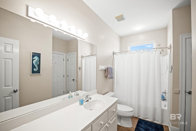 bathroom with visible vents, toilet, wood finished floors, a shower with shower curtain, and vanity