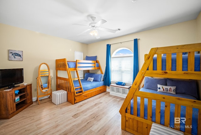 bedroom with ceiling fan, wood finished floors, visible vents, and baseboards