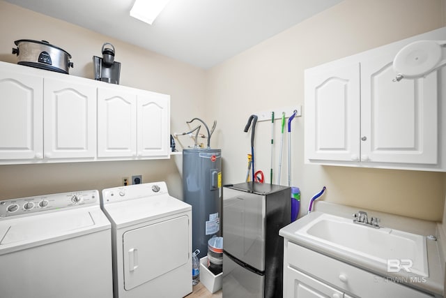 washroom with washer and dryer, cabinet space, water heater, and a sink